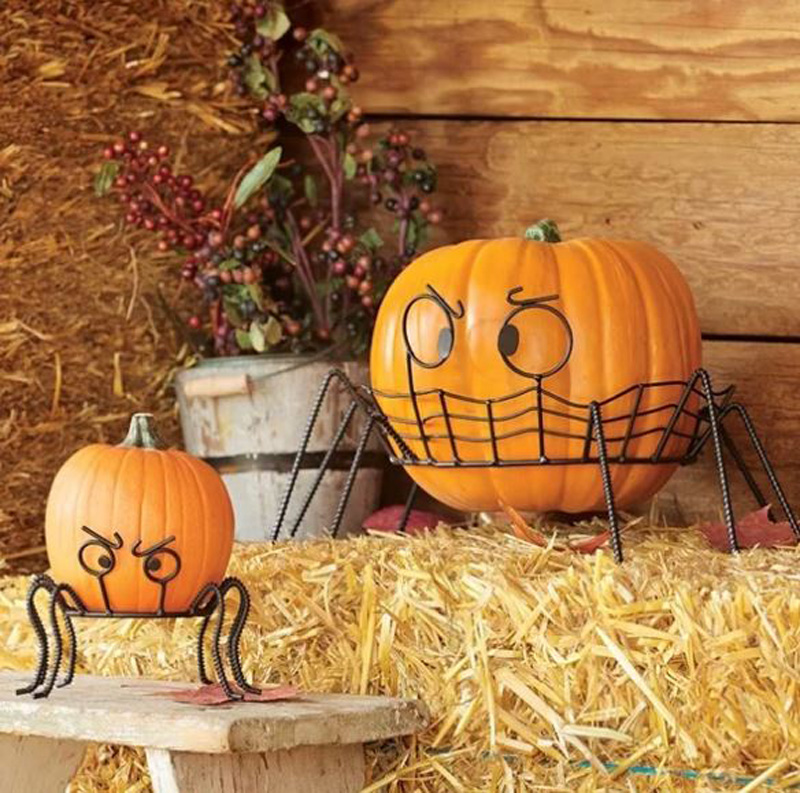 Perfect no-carve pumpkins held in fire-frame spider-shaped holders