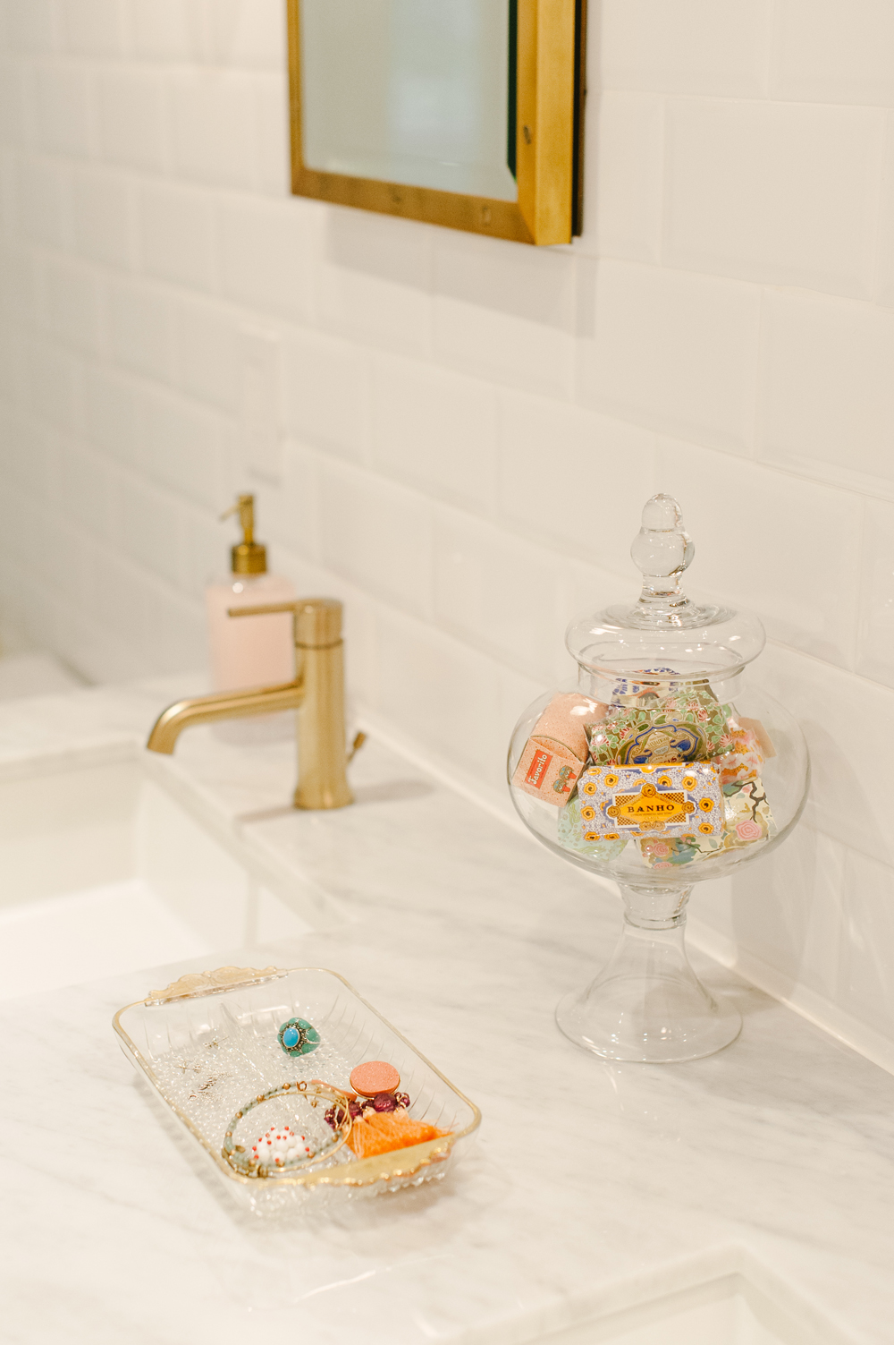 Decorative soaps on display in glass canister on bathroom vanity
