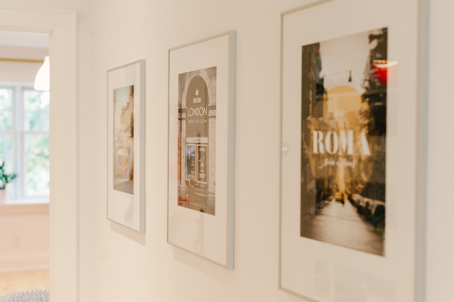 Travel posters framed in a hallway
