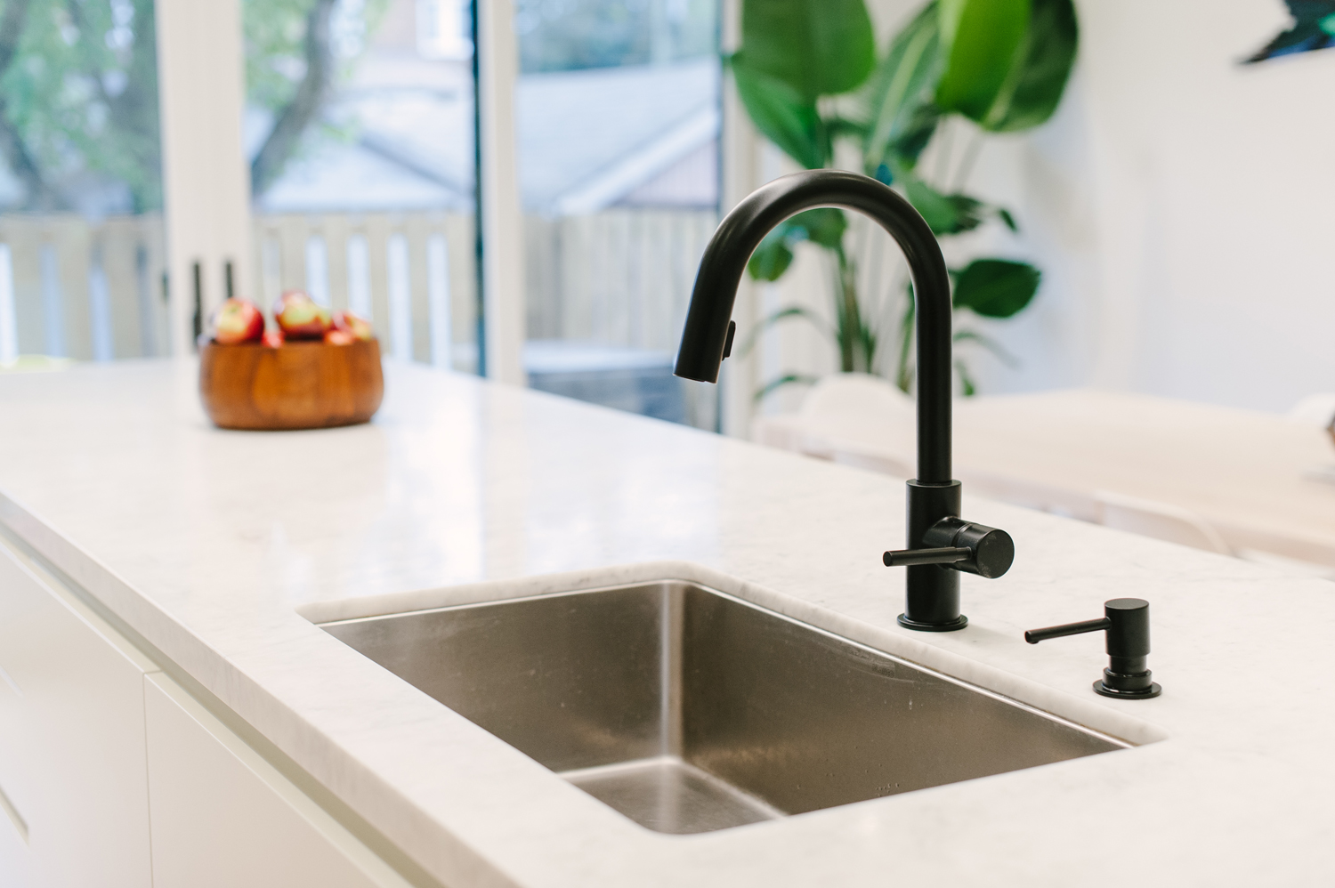 Black kitchen faucet mounted on white counter