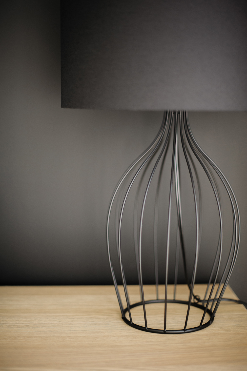 Black wire table lamp against a black wall