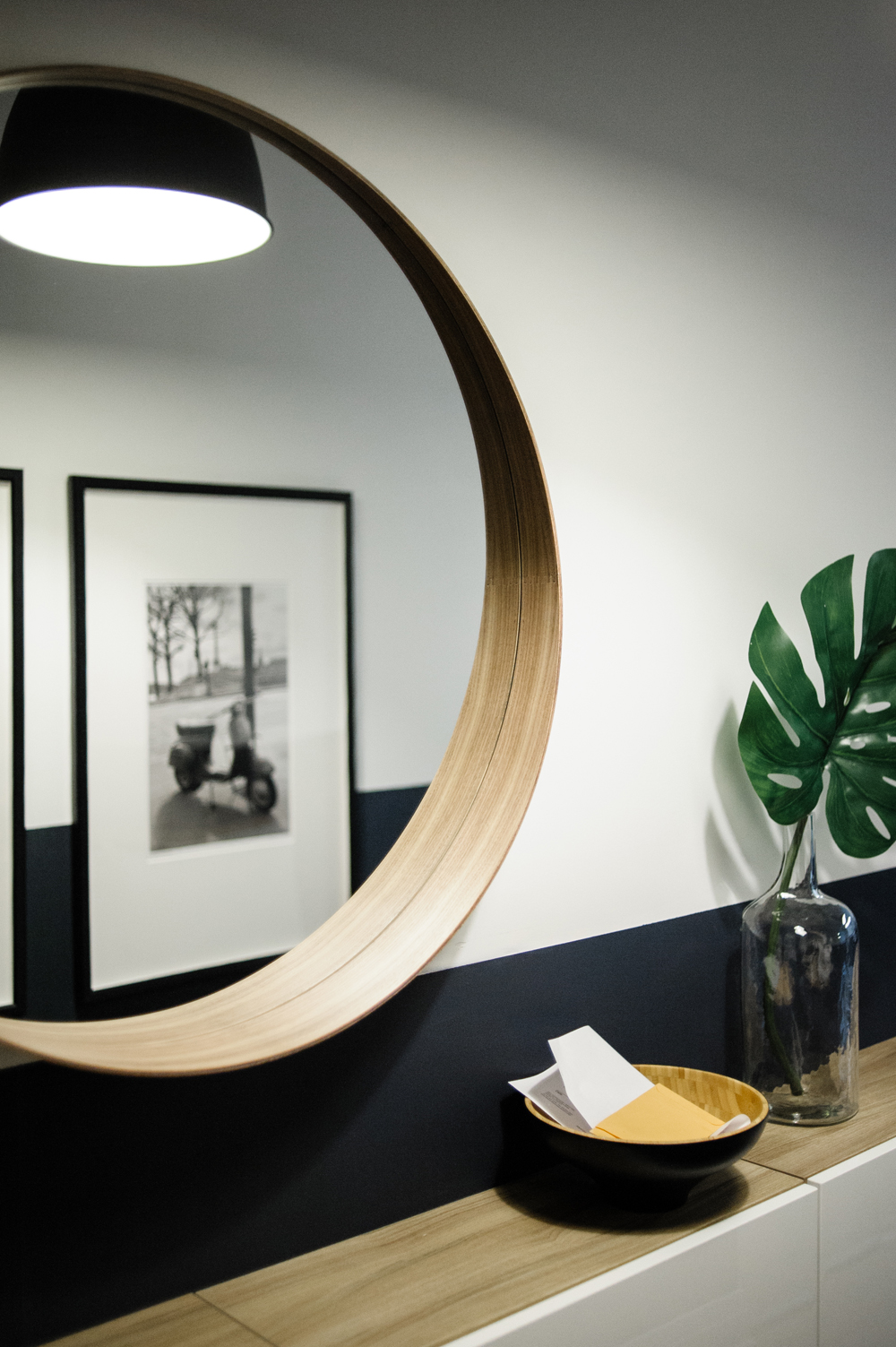 Round mirror hung over hallway console table