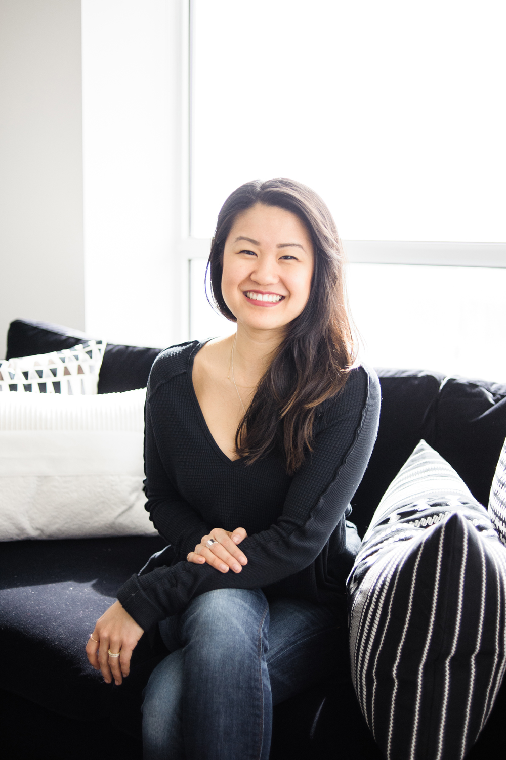 Interior designer Natalie Chong seated on a sofa