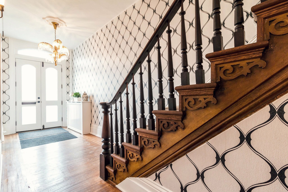 Gorgeous historic staircase updated with patterned wallpaper.