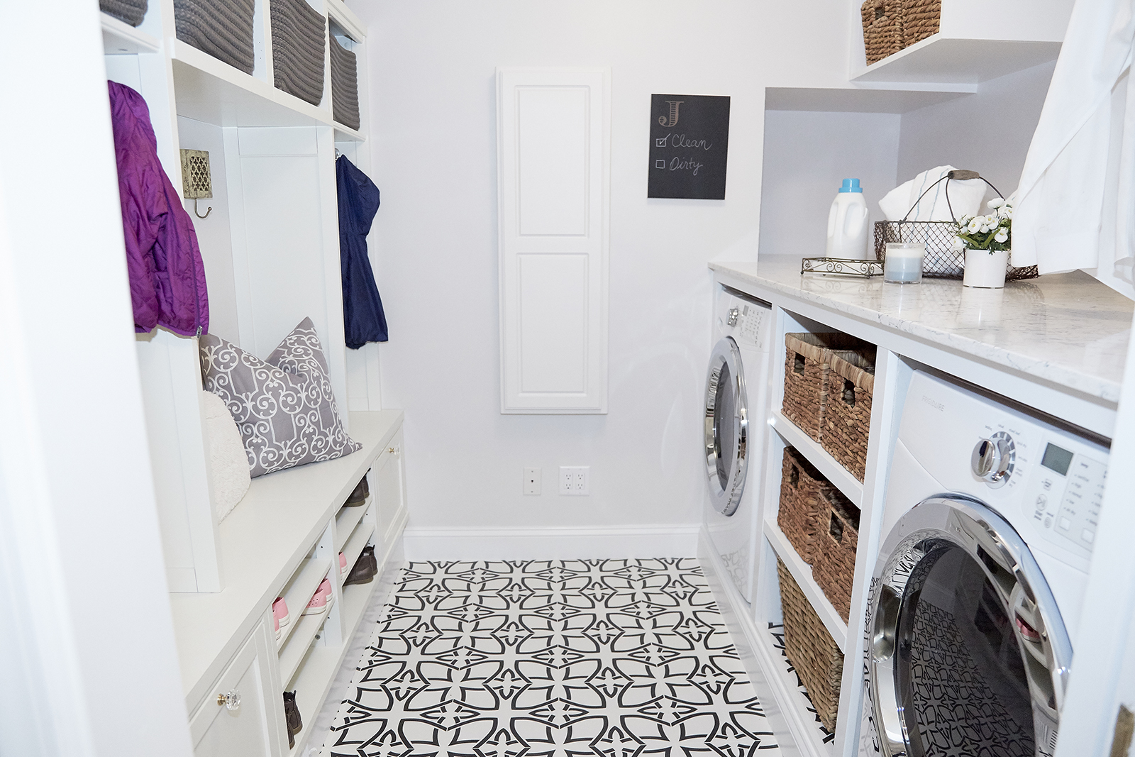 Modern white mudroom and laundry room design with bold floor tiles.