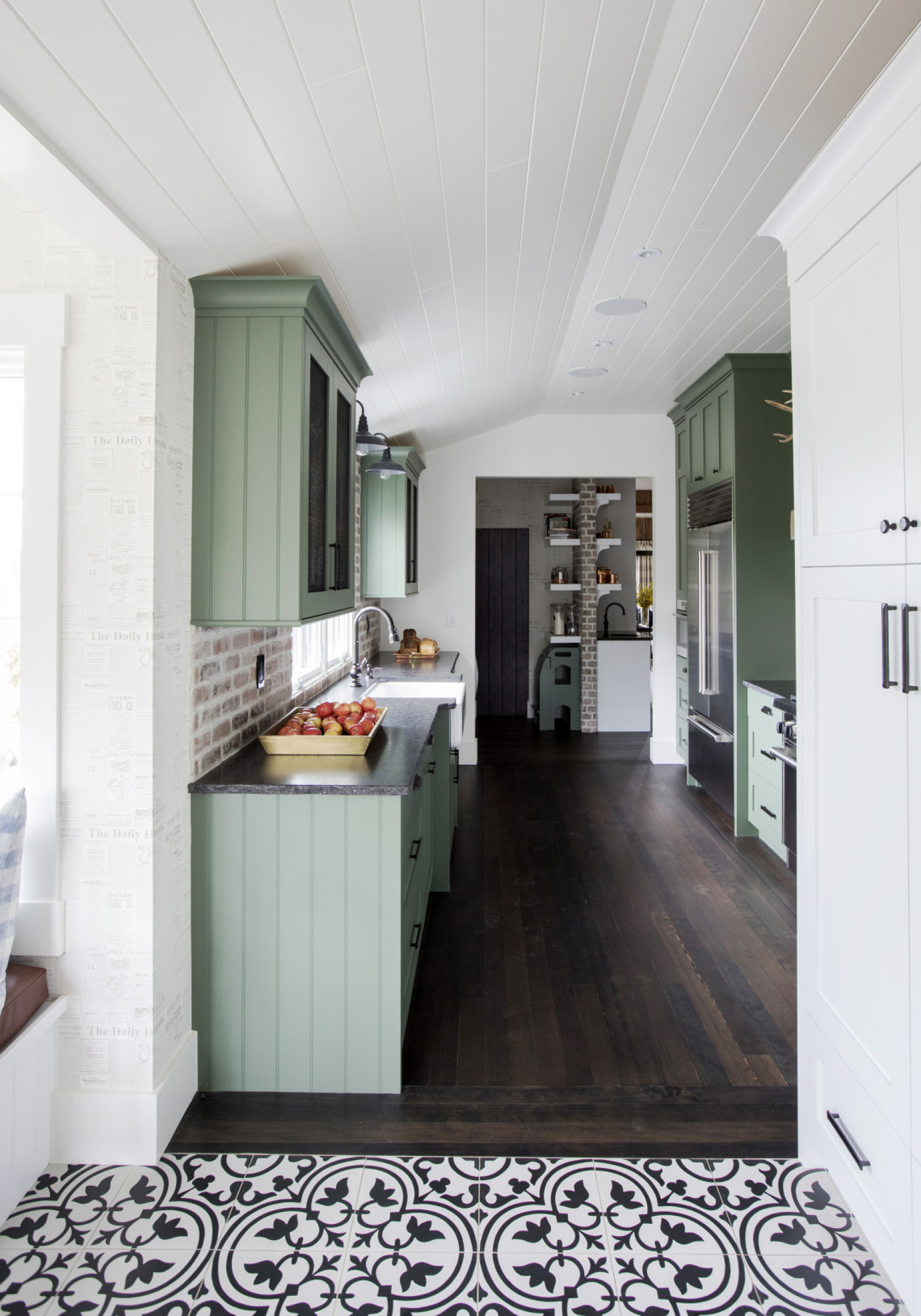 gallery kitchen with avocado green cabients, dark wood floor, white and black tile in foreground