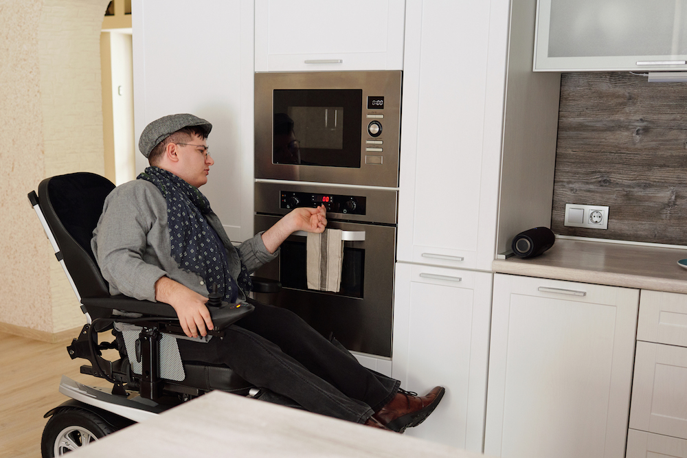 physically impaired man switching on oven in kitchen