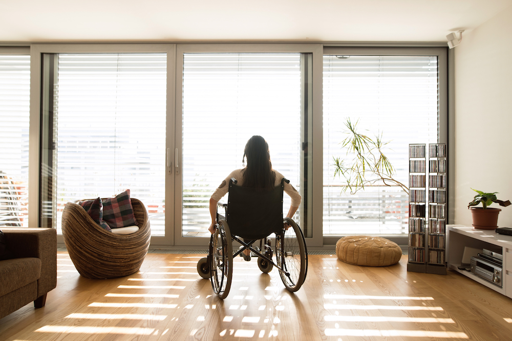 woman in wheelchair on wood floors at home