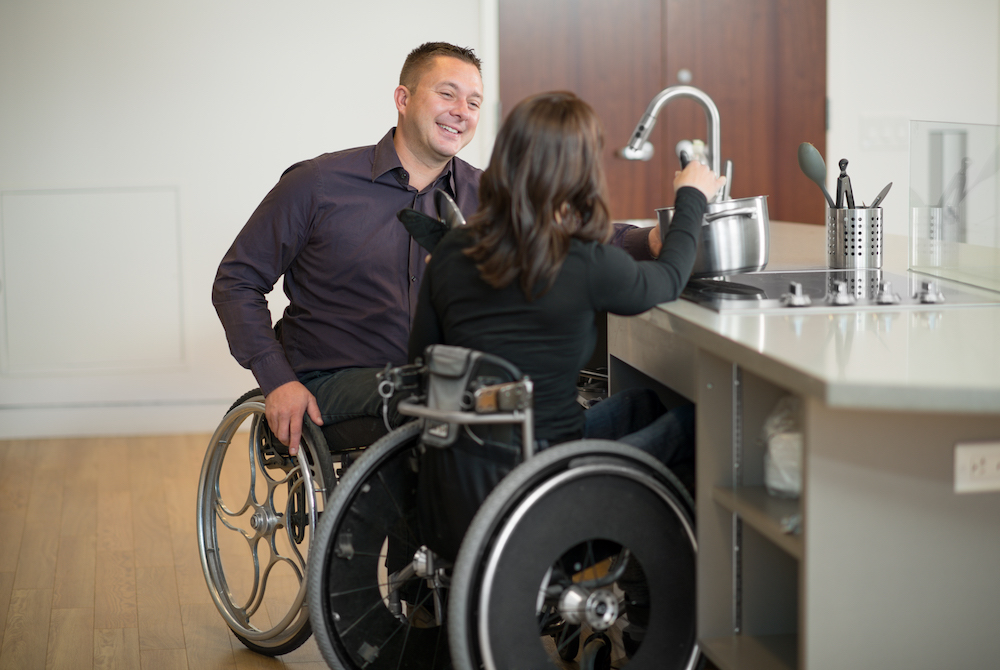 couple in wheelchairs at kitchen sink