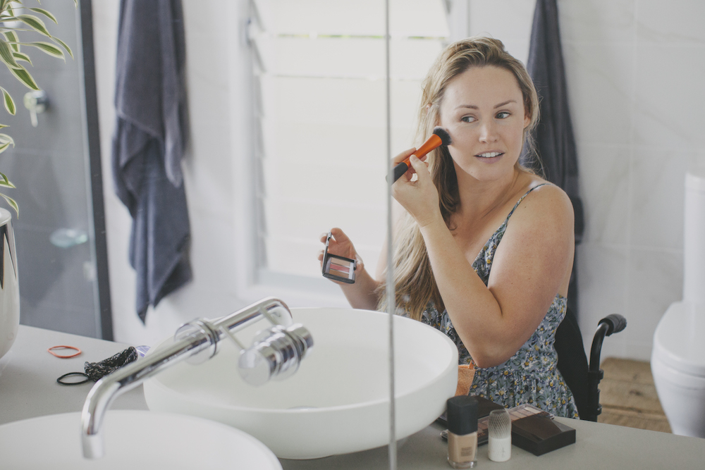 woman applying make up in her bathroom