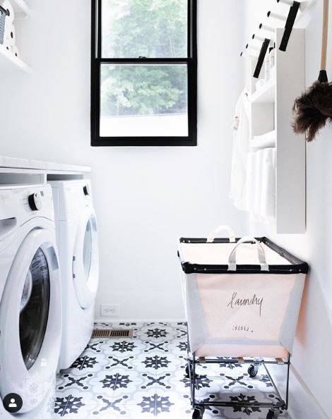 Neatly organized laundry room with patterned flooring and basket for clean clothing