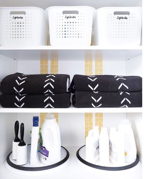 Laundry room shelving with detergents, folded towels and organizational baskets