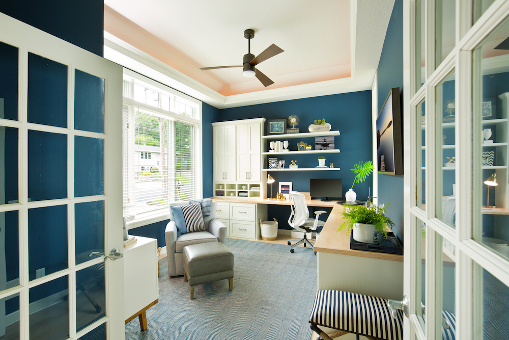 contemporary blue home office with ceiling fan and comfy chairs