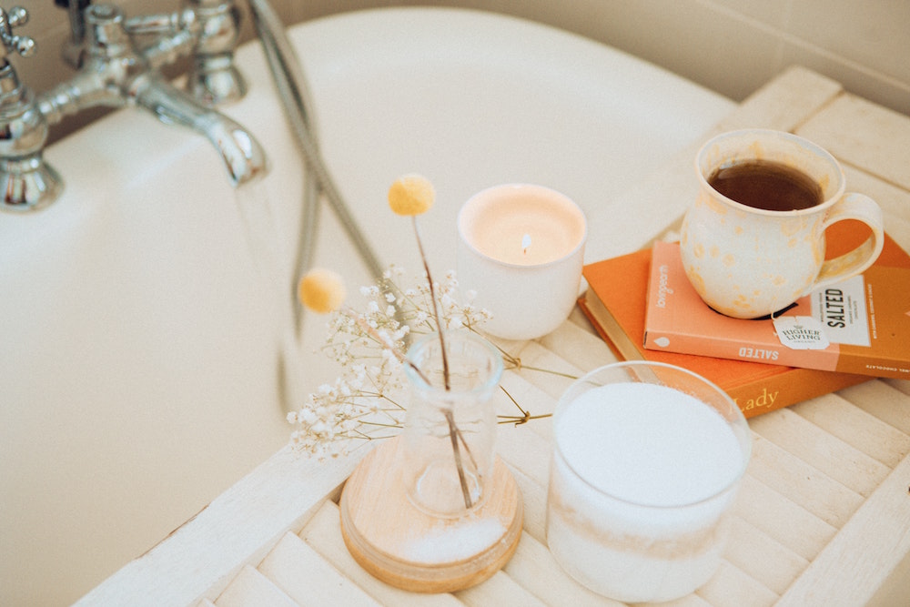 bathtub with books and tea on tray