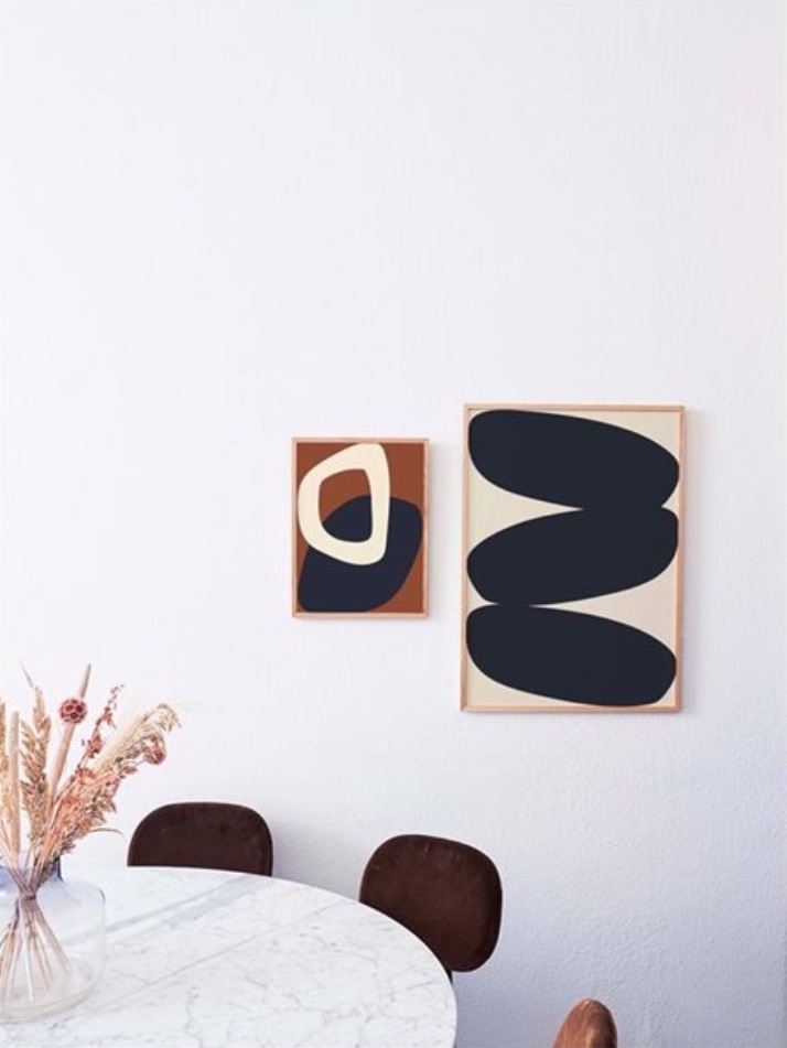 two framed abstract prints on wall in white room