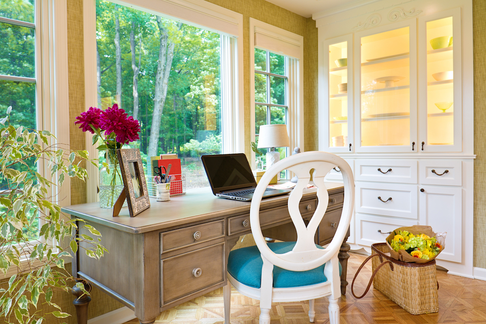 Home office desk with windows and flowers