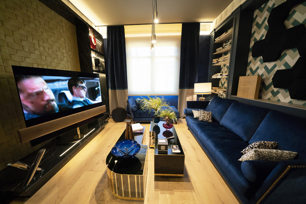 A narrow home screening room with blue furnishing and blackout curtains