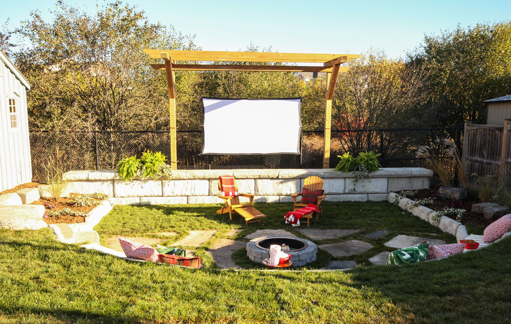 An outdoor screening space complete with a firepit and a shed with movie snacks