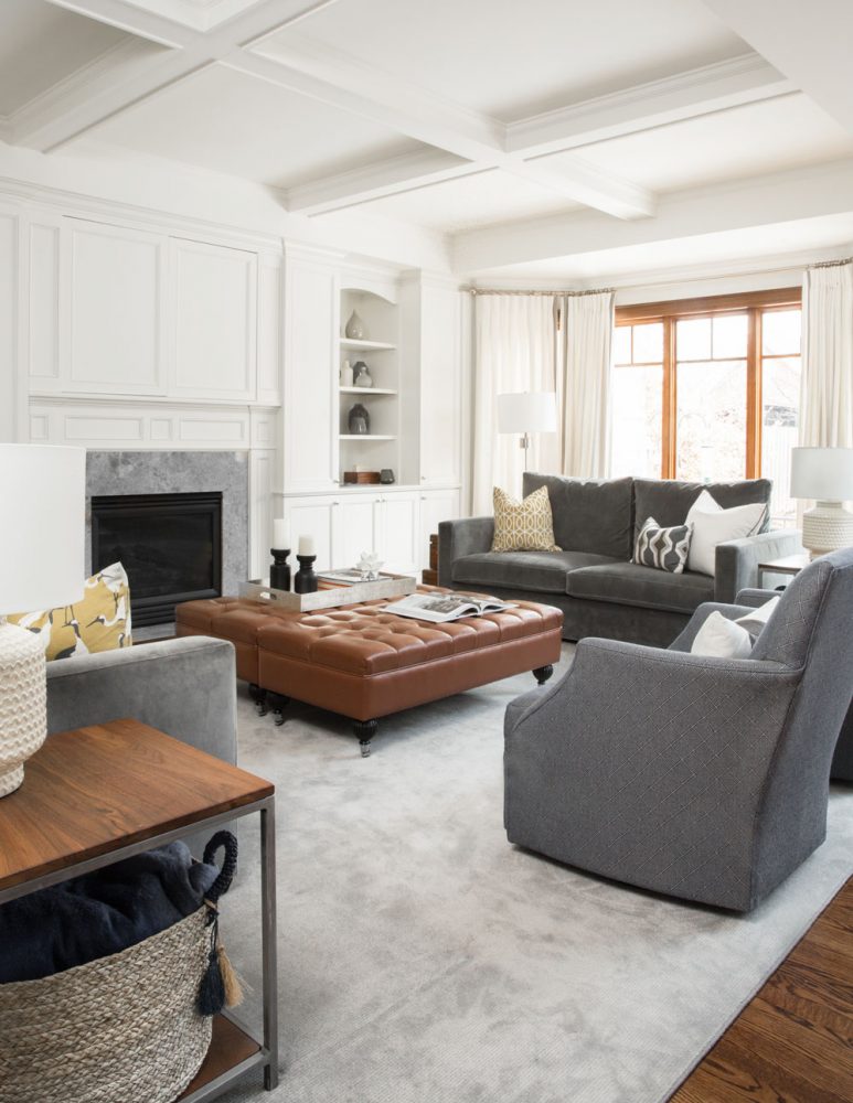 white coffered ceiling living room with fireplace and caramel tufted ottoman coffee table