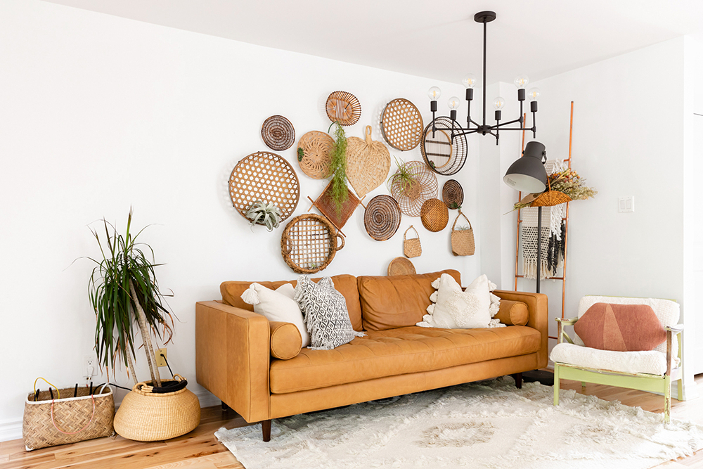 Living room with brown leather couch and wicker art hanging above the couch