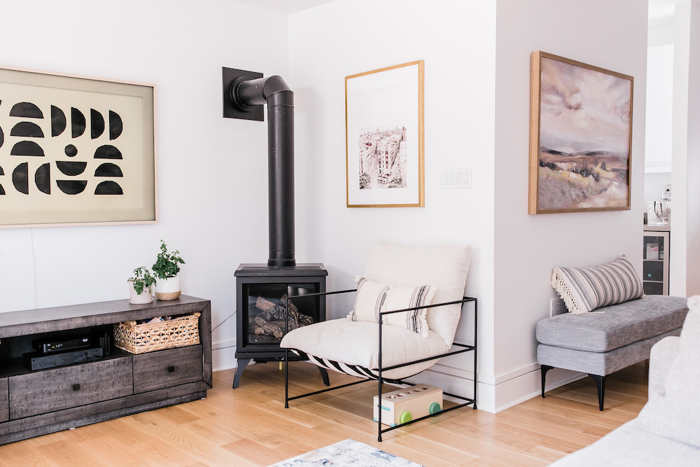 cozy white living room with black fireplace and framed art on walls
