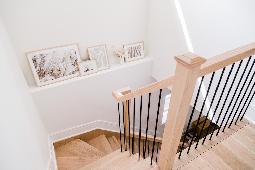 wooden stair case with ledge featuring framed images