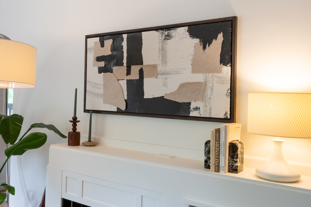 framed art over white fireplace