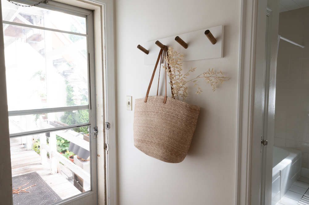 white entryway with wooden hooks