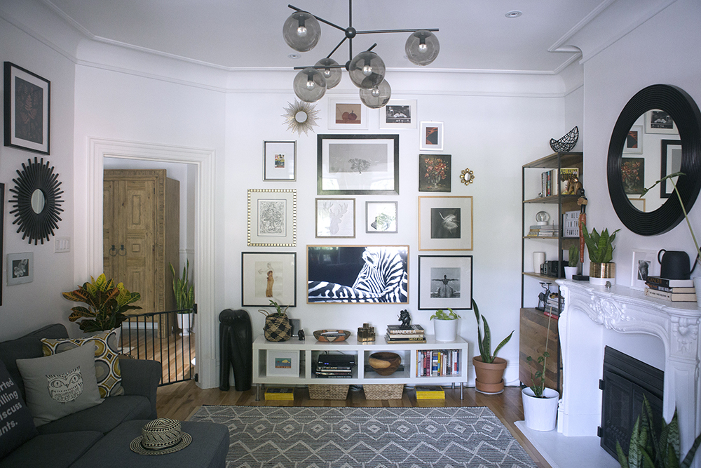Living room with white shelving and gallery wall above