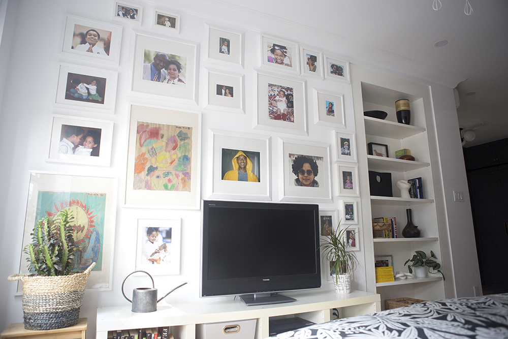 Bedroom wall with TV and gallery wall of prints, photos, etc.