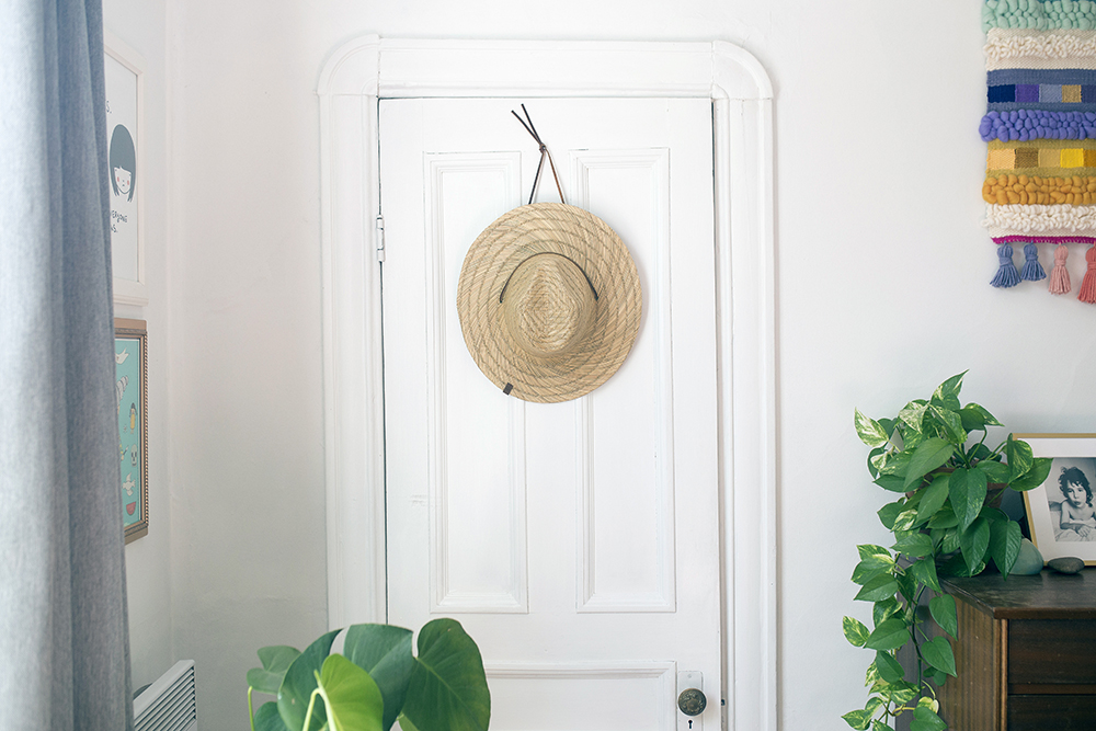 White door with straw hat hanging from it