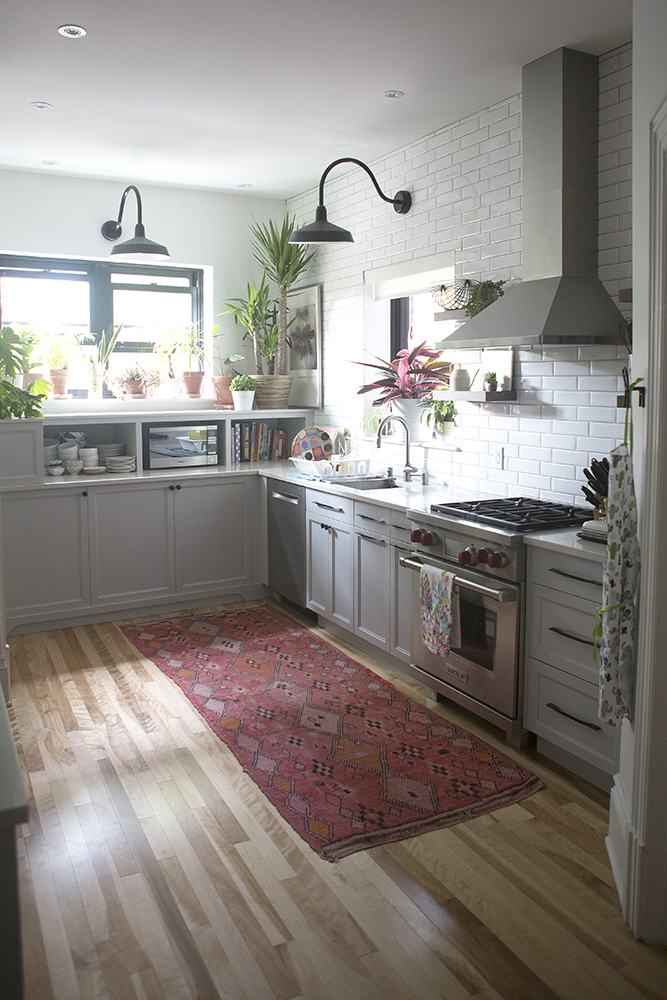 Boho chic kitchen with red floor runner and white subway tiles on the walls