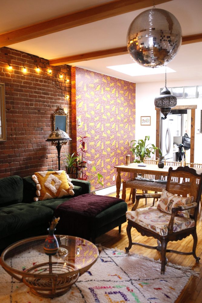 living room and dining room with brick wall and wallpapered wall