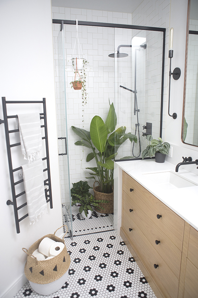 Bathroom with floral tiled floor, and plants in glass shower