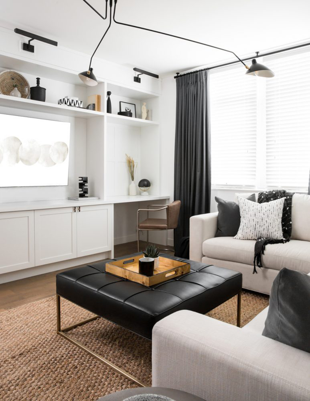 A black and white renovated living room with plenty of custom storage and sleek, contemporary furniture
