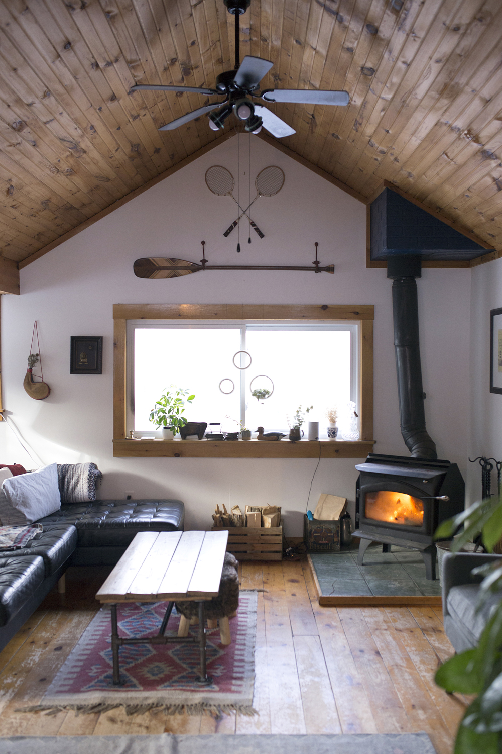 A cozy cottage with high sloped ceilings and a wood-burning fireplace