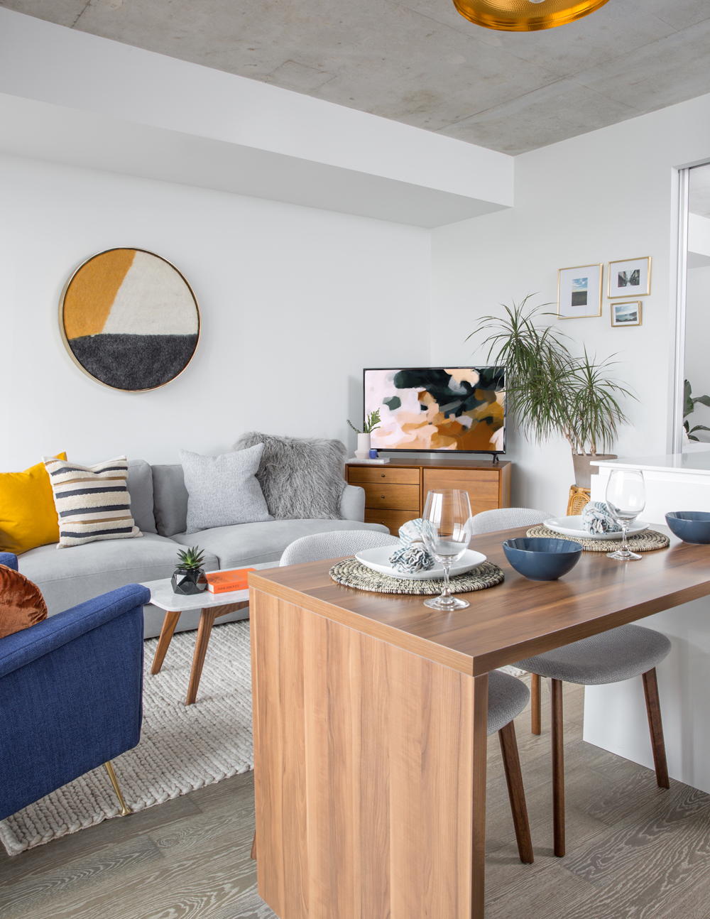 A renovated living room with small dining table and pops of colour