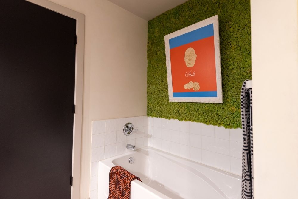 bathroom with green nubby art wall and black door