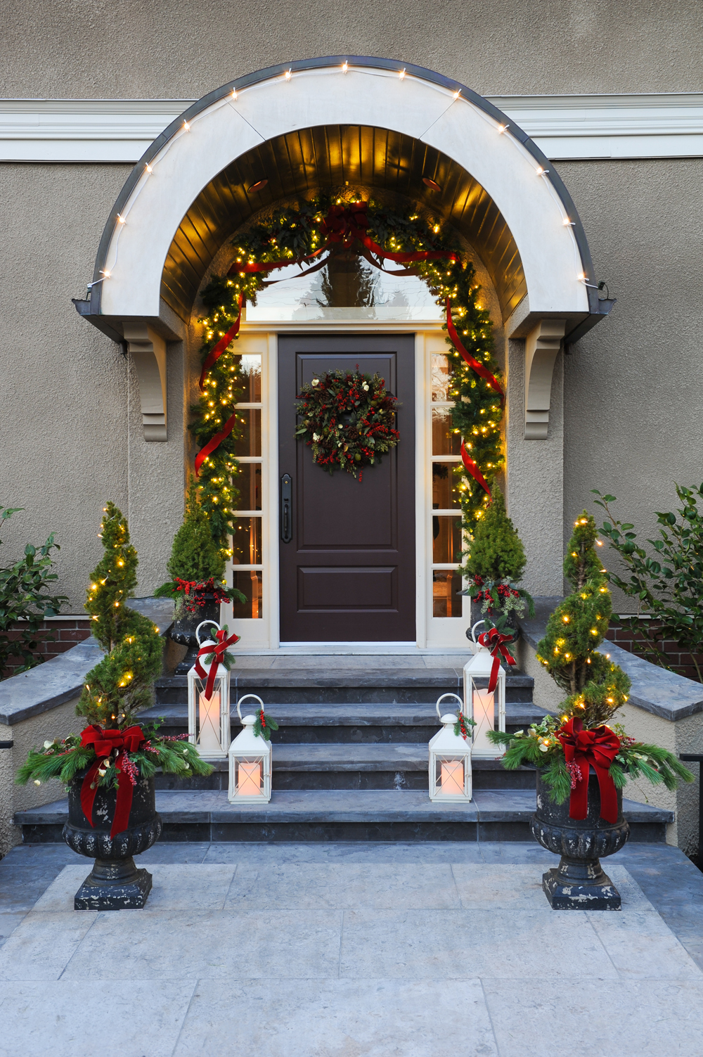 Front door with holiday garland and lights