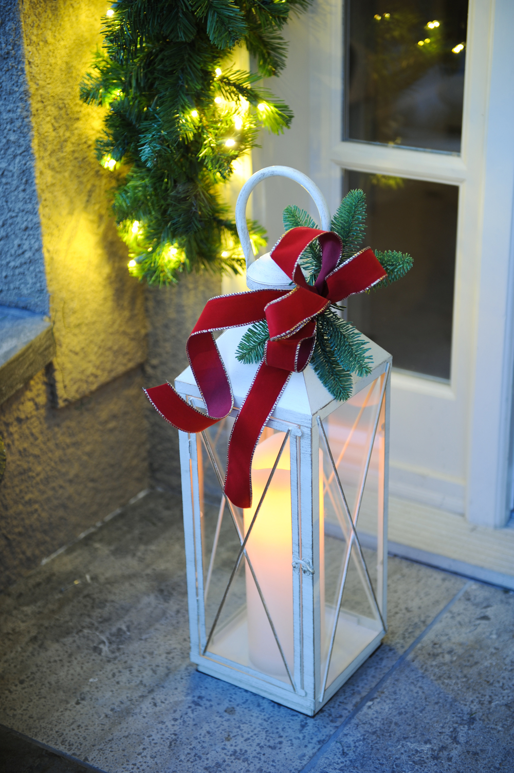 White holiday lantern tied with a red ribbon
