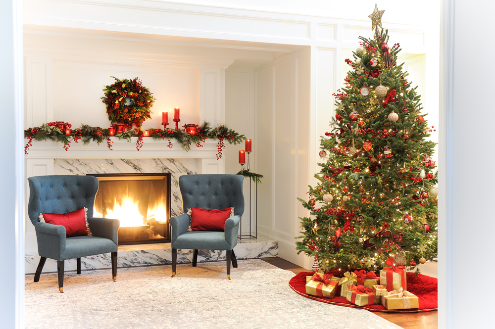 A festive family sitting room with a decorated Christmas tree and a wood-burning fireplace
