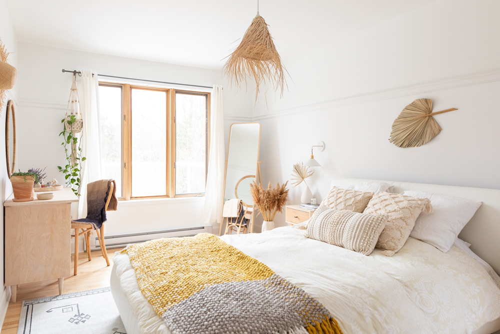 cozy white bedroom with white bed with yellow-and-grey blanket
