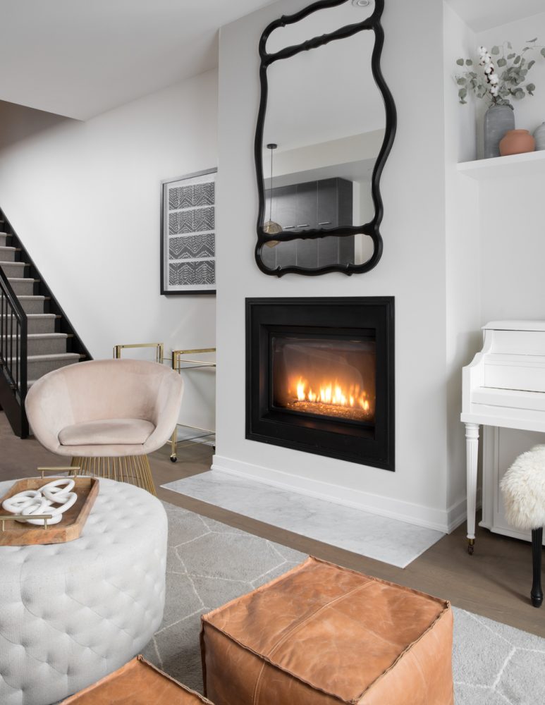 white living room with fireplace and mirror