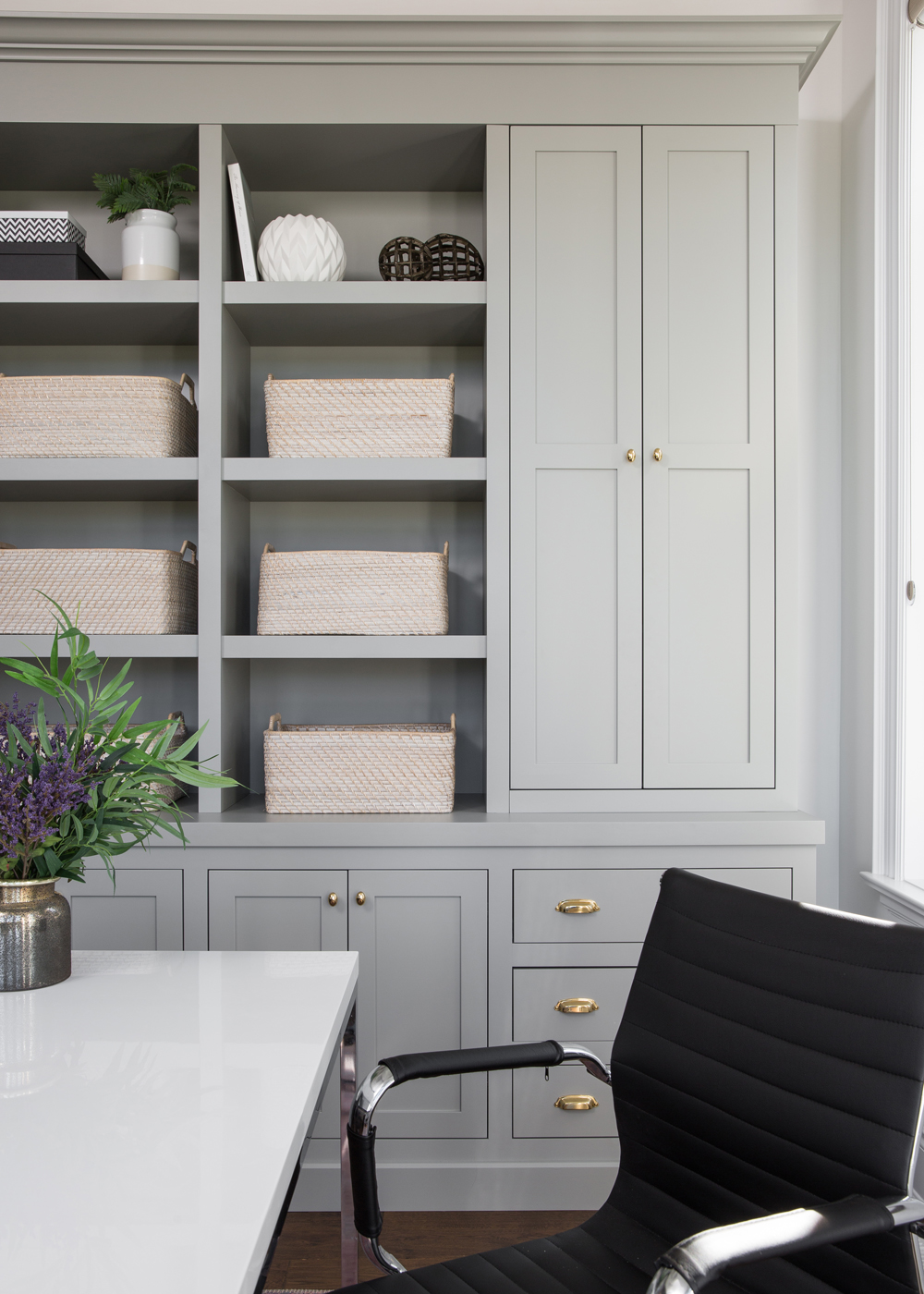 grey built-in shelves with baskets in office with black chair, white and chrome desk