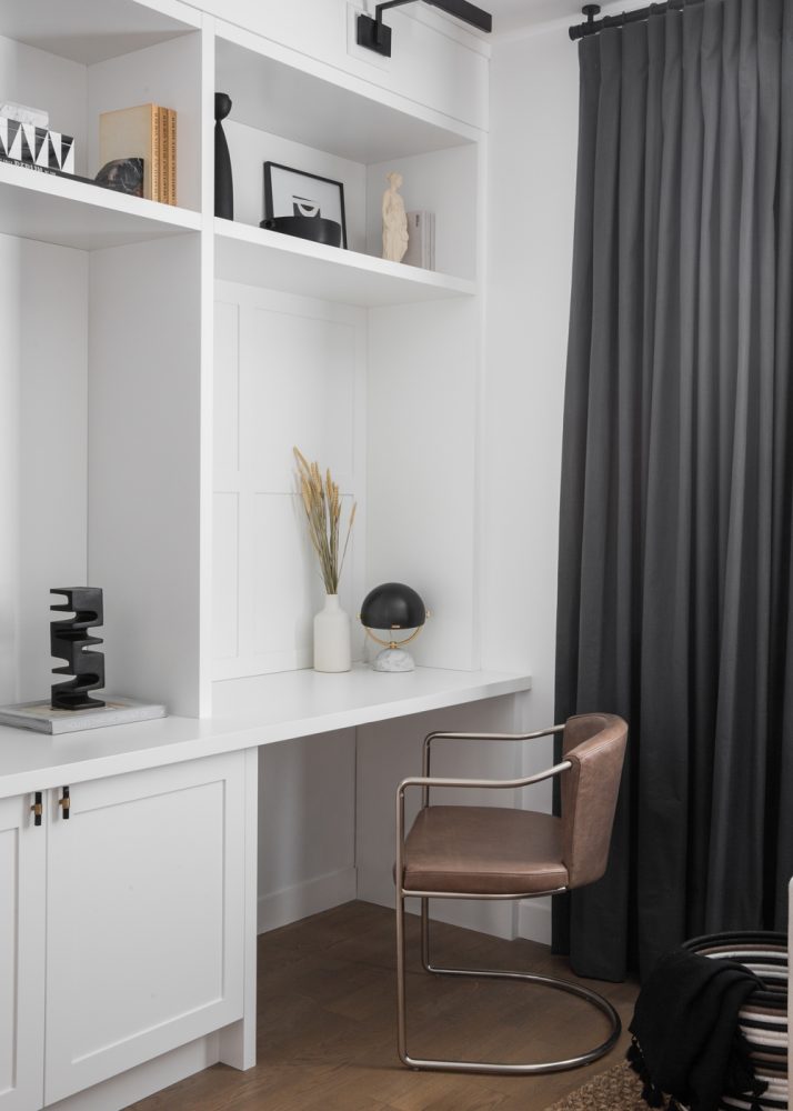 office nook in white built-in cabinetry with leather chair