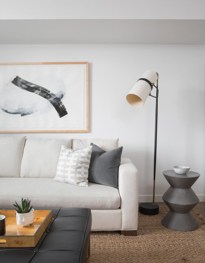 white family room with sectional couch and framed art on wall