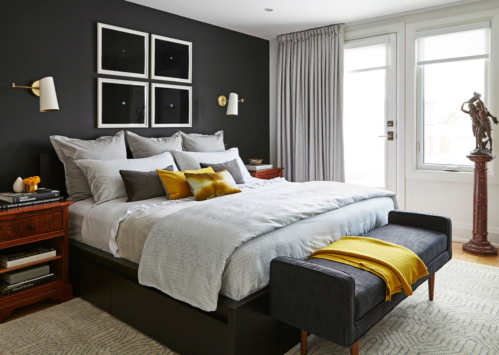 A master bedroom with custom-made blackout drapery, area rug and dark furniture