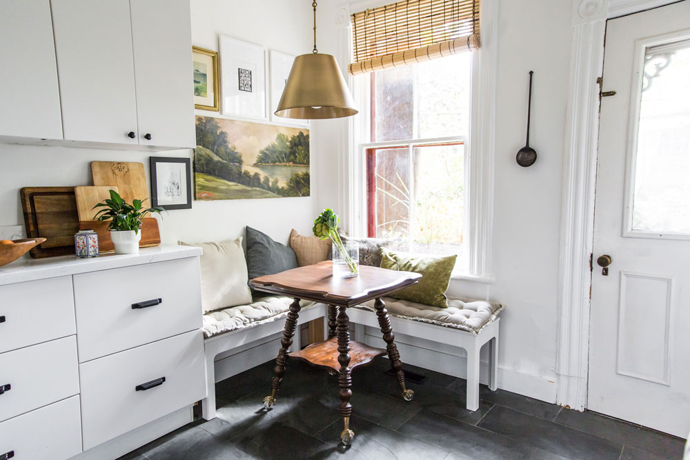 A built-in breakfast nook with vintage artifacts in a white kitchen