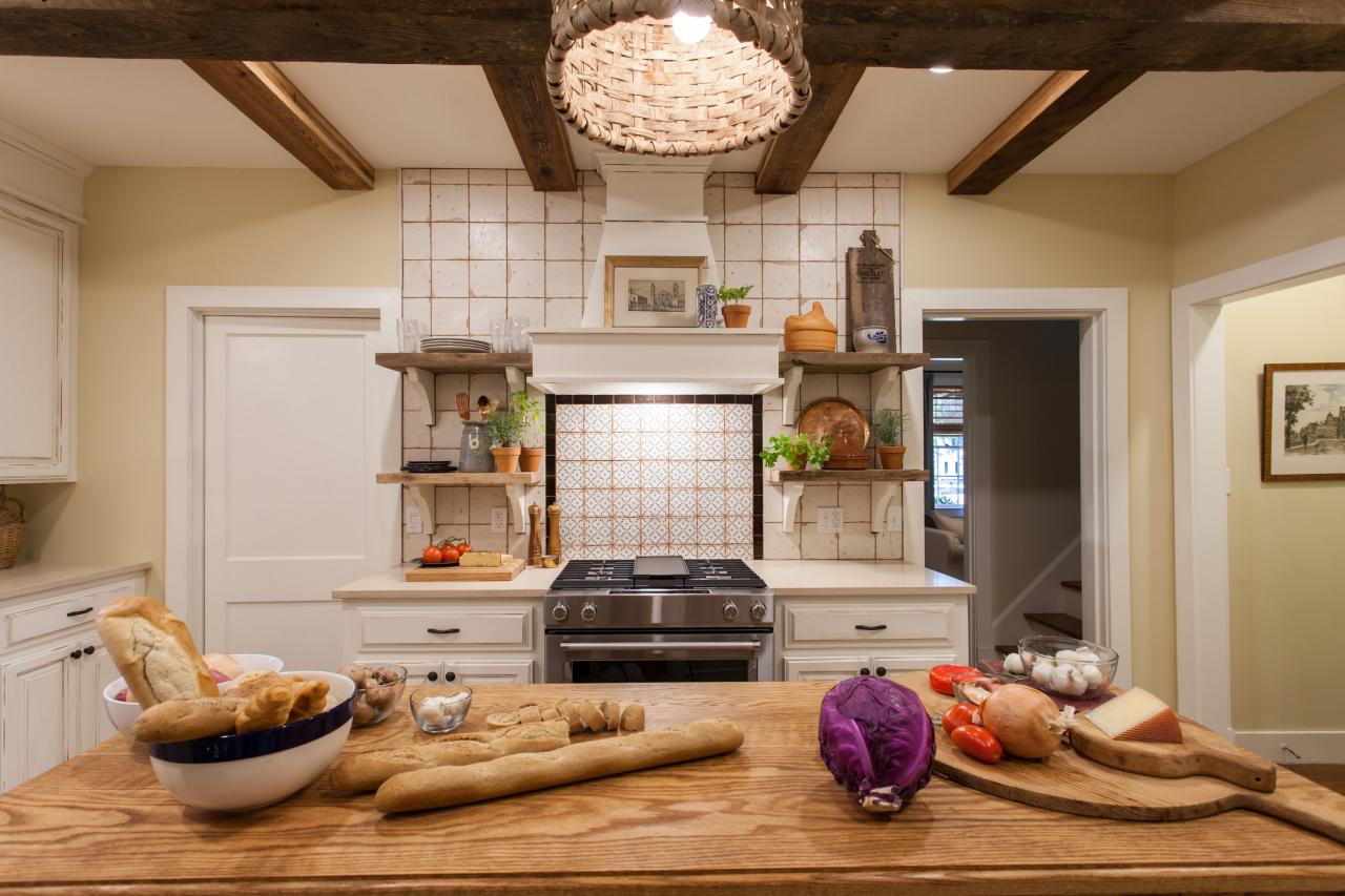 A kitchen island with fresh bread and vegetables.