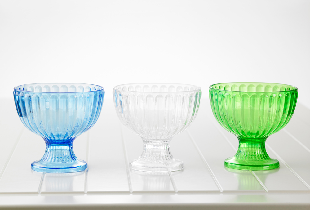 Three pieces of glassware in blue, clear and green